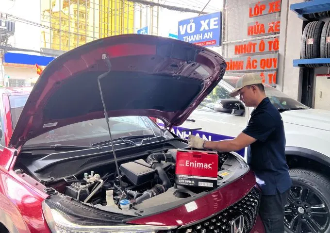 Kỹ thuật viên lắp đặt bình ắc quy Enimac cho xe ô tô Honda tại gara