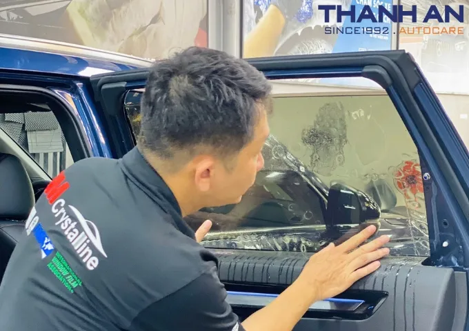 Kỹ thuật viên dán phim cách nhiệt 3M tỉ mỉ cho siêu xe tại gara Thanh An Autocare