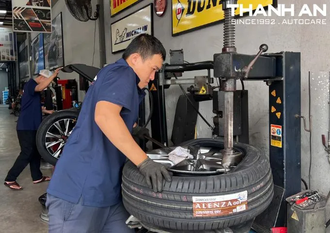 Kỹ thuật viên đang thay lốp Bridgestone 225/55R19 Alenza 001 Nhật Bản tại gara