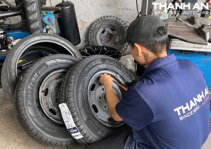 Kỹ thuật viên đang kiểm tra áp suất lốp xe BMW 320i tại gara