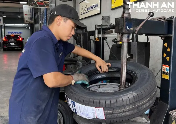 Kỹ thuật viên đang thay lốp xe BMW 320i tại gara