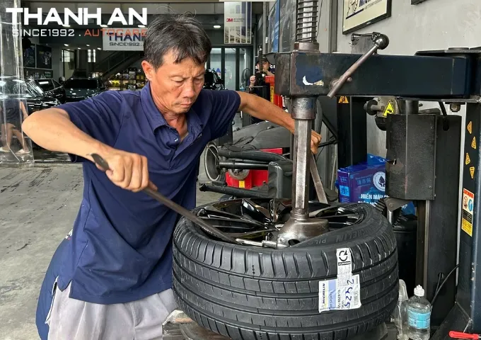 Kỹ thuật viên đang tháo lốp xe Honda Civic cũ để thay mới