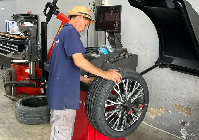 Kỹ thuật viên cân bằng động lốp xe ô tô tại gara