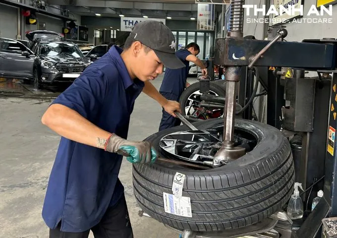 Kỹ thuật viên đang thay lốp xe Kia Sportage chính hãng tại gara