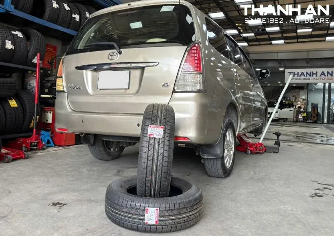 Xe Toyota Innova đang được nâng lên để thay lốp mới tại gara