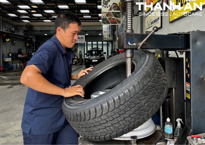 Kỹ thuật viên đang thay lốp xe Toyota Land Cruiser chính hãng tại gara