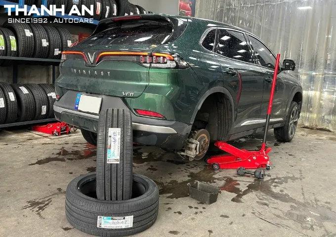 Xe Kia Sedona đang được nâng lên để thay lốp mới tại gara