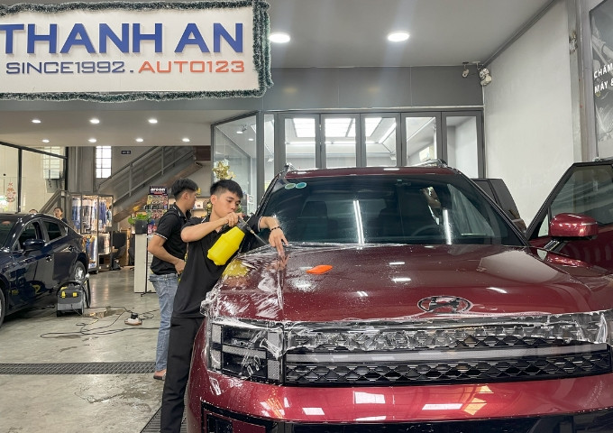 Kỹ thuật viên đang dán PPF xe ô tô để bảo vệ lớp sơn zin.