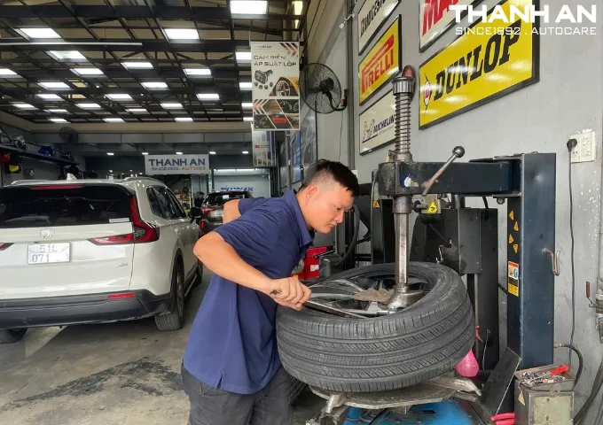 Kỹ thuật viên ô tô thay lốp xe ô tô cho xe VinFast VF 6 tại quận 7