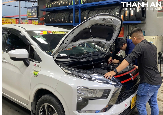 Kỹ thuật viên thay bình ắc quy Enimac cho xe ô tô Mitsubishi tại gara
