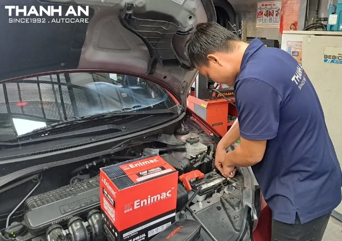Kỹ thuật viên lắp đặt bình ắc quy Enimac cho xe ô tô Honda tại gara