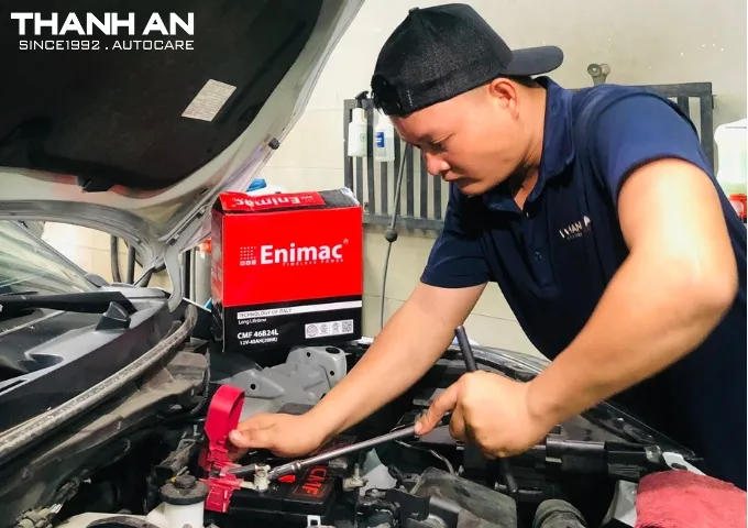 Kỹ thuật viên thay bình ắc quy Enimac CMF cho xe ô tô tại gara