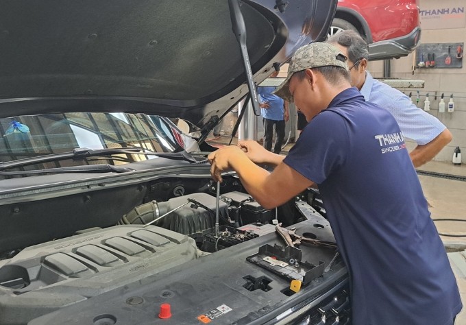 Kỹ thuật viên thay bình ắc quy Enimac cho xe ô tô Hyundai tại gara tphcm