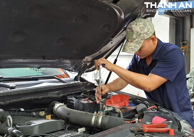 Kỹ thuật viên thay bình ắc quy Enimac cho xe ô tô Ford tại gara