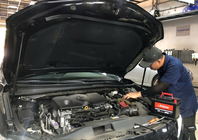 Kỹ thuật viên lắp bình ắc quy Enimac cho xe ô tô Toyota tại gara