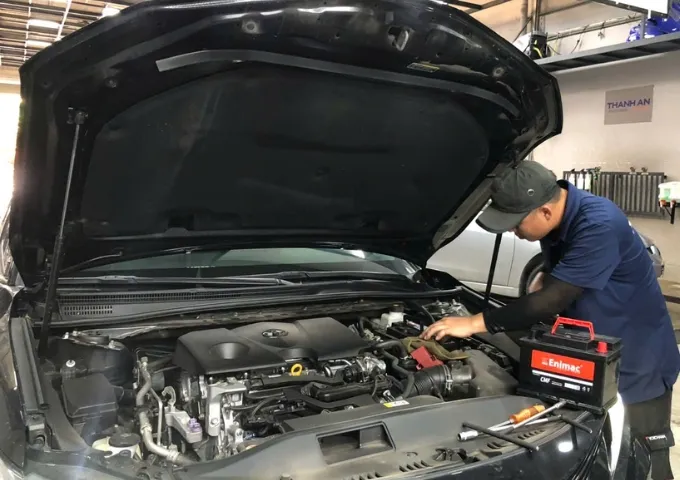 Kỹ thuật viên lắp bình ắc quy Enimac cho xe ô tô Toyota tại gara