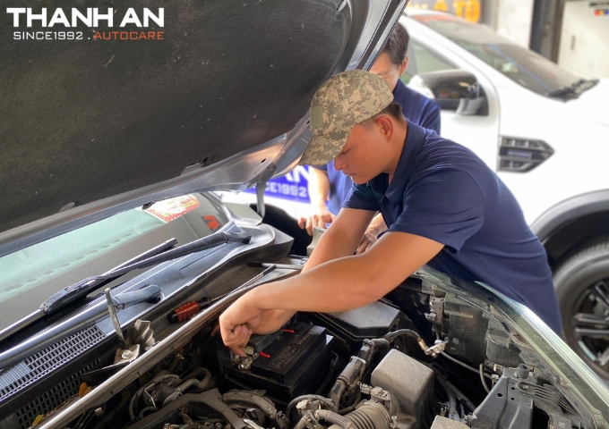 Kỹ thuật viên thay bình ắc quy Enimac cho xe ô tô Toyota tại gara tphcm