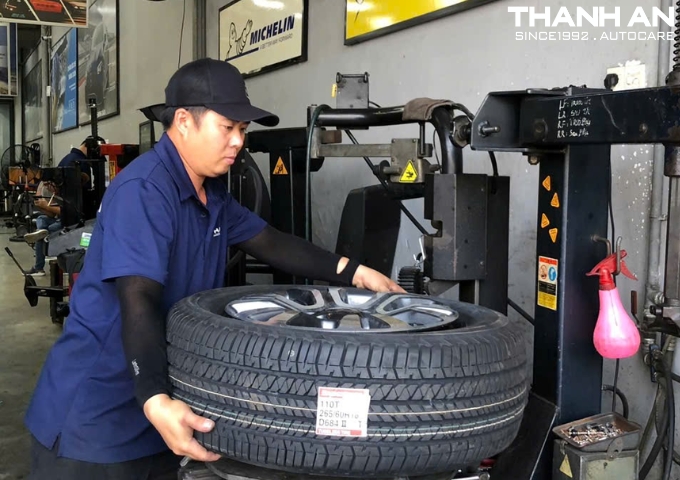 Kỹ thuật viên ô tô thay lốp Bridgestone 265/60R18 Dueler H/T 684 Thái Lan cho xe Ford Ranger tại quận 7