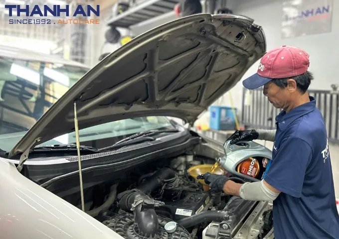 Kỹ thuật viên thay nhớt cho xe ô tô chuyển nghiệp tại gara