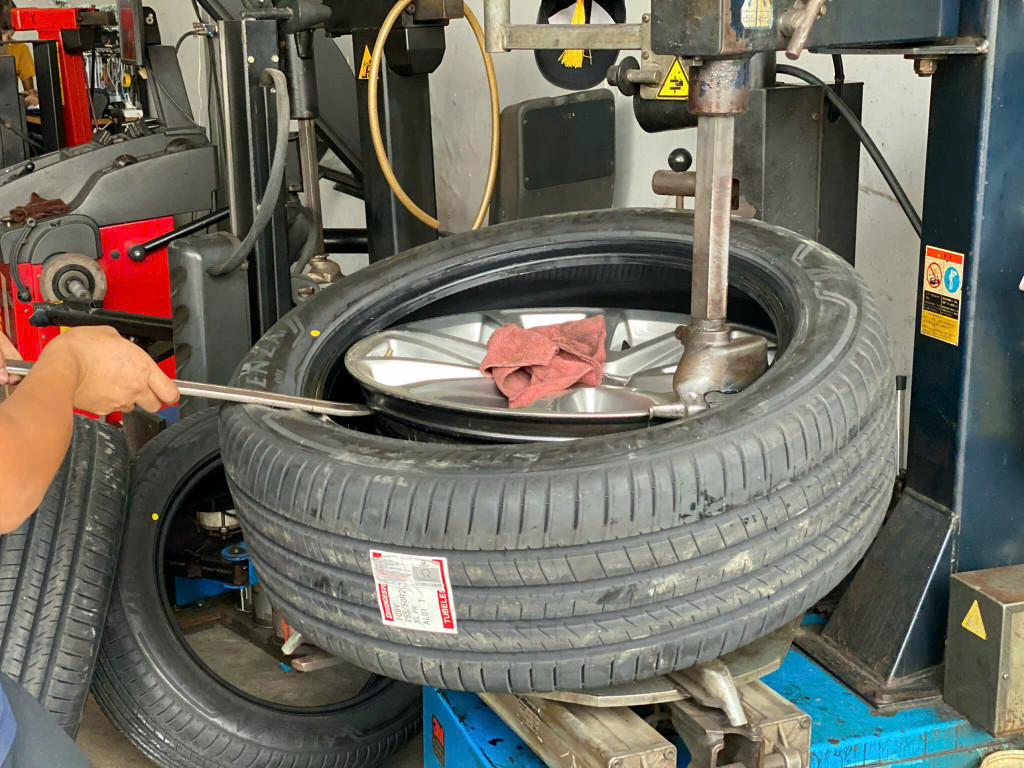 Nhân viên kỹ thuật đang thay vỏ Bridgestone 255/50R20 Alenza 001 Nhật cho khách tại gara Thanh An.