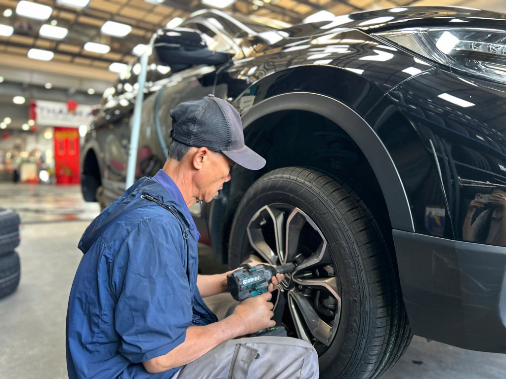 Nhân viên kỹ thuật đang tiến hành lắp đặt vỏ xe Kumho size 235/60r18 chuyên nghiệp tại gara Thanh An AutoCare.