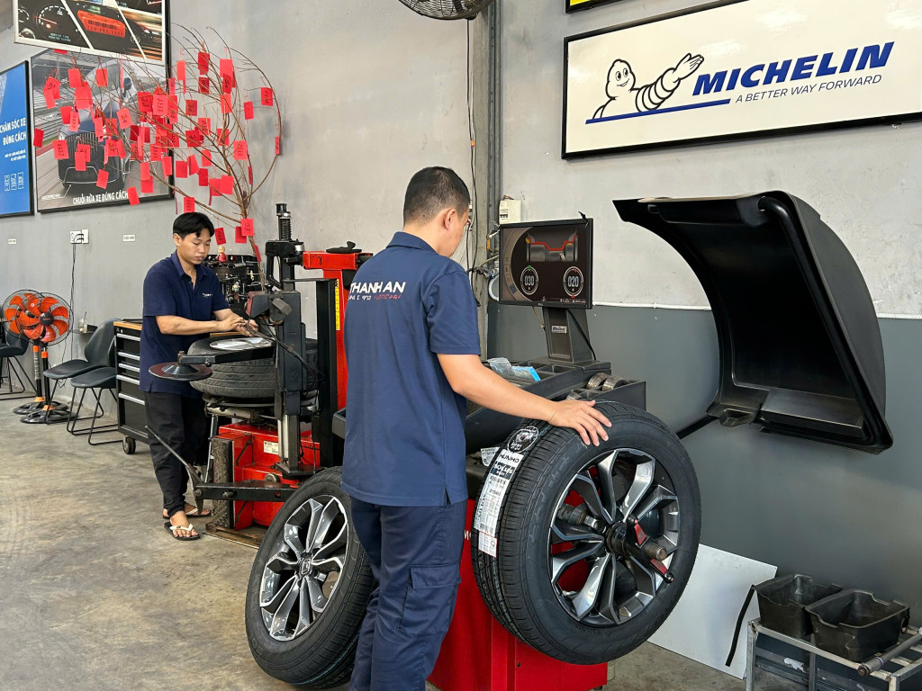 Hình ảnh KTV thực hiện quy trình thay vỏ xe ô tô Kumho 235/60r18 chính hãng cho khách hàng tại gara uy tín.