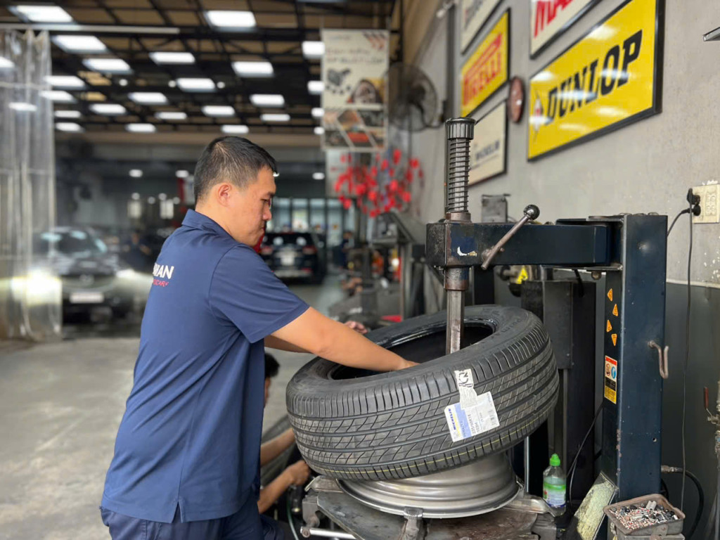 Thợ kỹ thuật gara Thanh An đang siết ốc cố định khi thay vỏ Michelin 235/60R18 cho xe khách hàng.