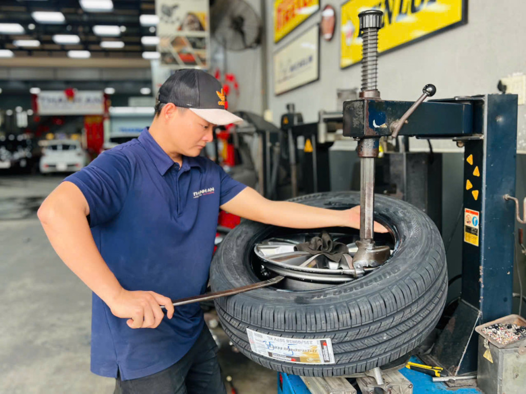 Nhân viên kỹ thuật đang lắp vỏ xe Hankook 235/60R18 cho dòng xe SUV tại hệ thống gara Thanh An AutoCare