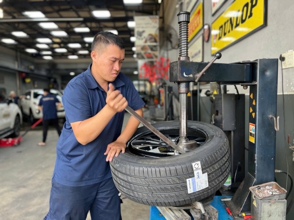 Nhân viên kỹ thuật kiểm tra và lắp vỏ Michelin 235/55R19 Primacy 4 SUV cho Kia Carnival tại gara