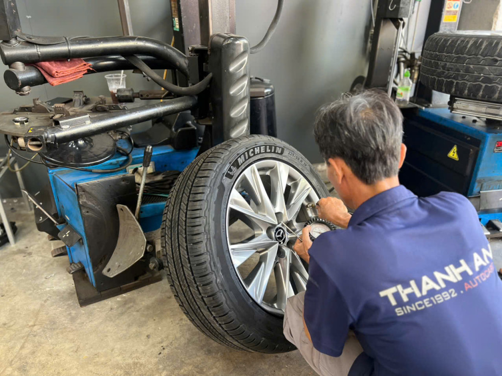 Kỹ thuật viên lắp đặt lốp Michelin 225/55R19 Primacy SUV Thái Lan cho xe khách tại gara Thanh An AutoCare