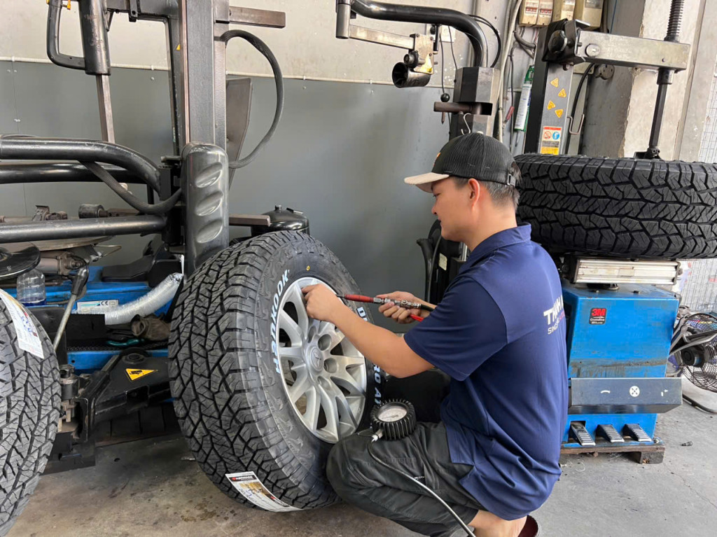 Kỹ thuật viên thực hiện lắp bộ vỏ Hankook 265/65R17 chất lượng cho khách hàng tại gara Thanh An AutoCare