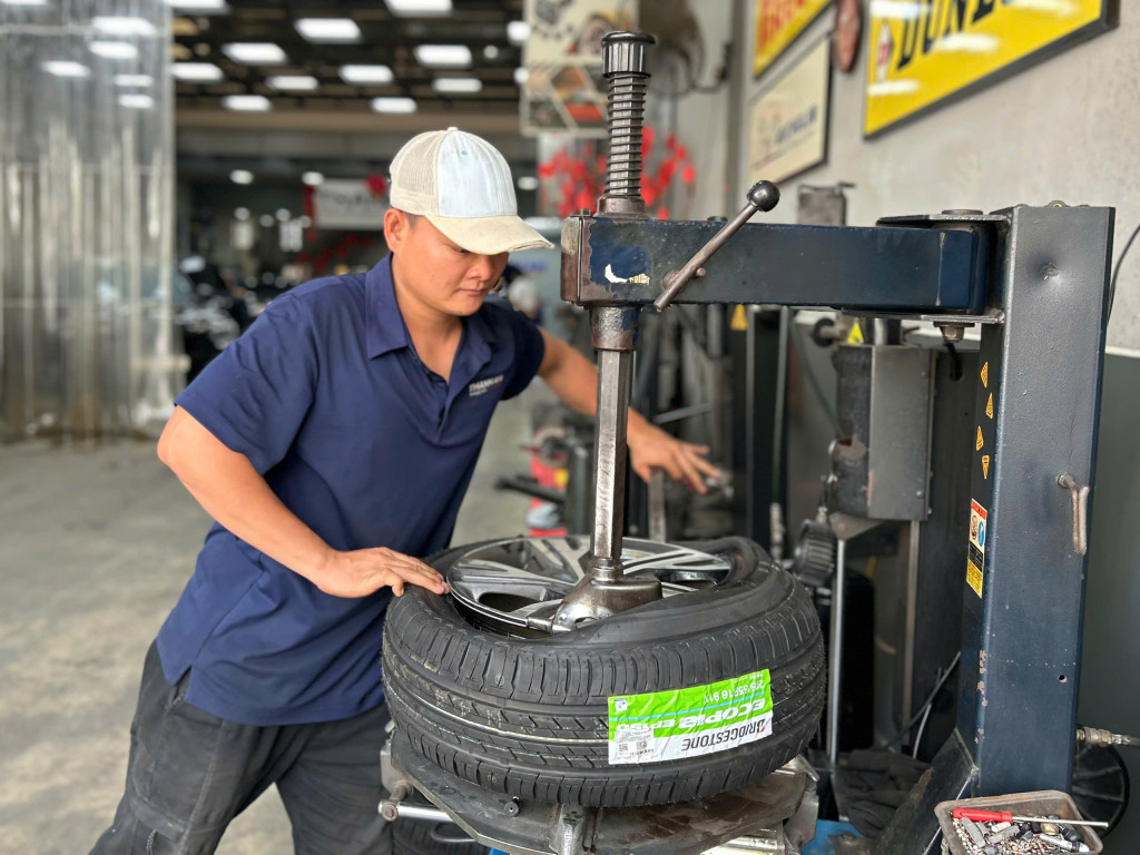 Nhân viên kỹ thuật đang kiểm tra và thay vỏ xe Bridgestone 205/55r16 mới cho khách tại Thanh An AutoCare.