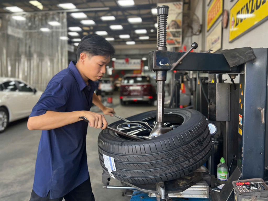 Nhân viên KTV thay vỏ xe Michelin 235/55r19 êm ái hàng đầu thế giới cho khách hàng tại xưởng kỹ thuật